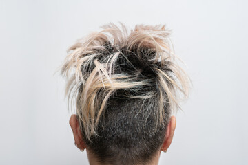 Undercut hairstyle with highlighted hair on a woman's head. Rear view. Defiant hairstyle.
