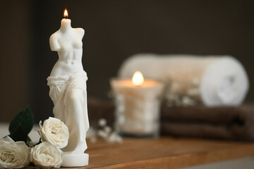 Beautiful Venus De Milo candle and white roses on wooden table in room, space for text © New Africa