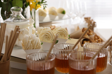 Tasty treats and glasses of drink on table. Sweet buffet