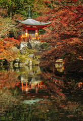 秋の京都、醍醐寺の弁天堂と紅葉が池に映る風景