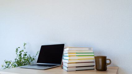 机上の本とノートパソコン