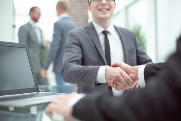 close up. smiling Manager shaking hands with the client