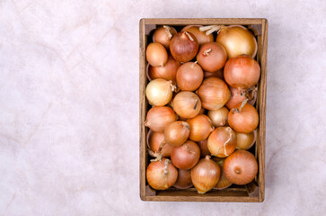 Fresh yellow onions in a wooden box
