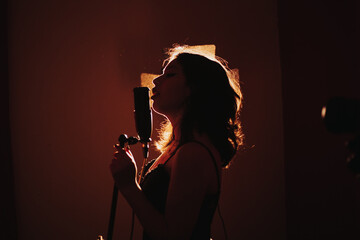 silueta de Joven cantante apasionada a contraluz