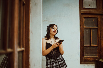 Mujer joven escuchando música con su teléfono móvil