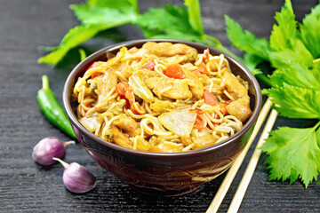 Noodles with cabbage and chicken in bowl on dark board
