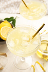 Delicious bee's knees cocktail and ingredients on white wooden table