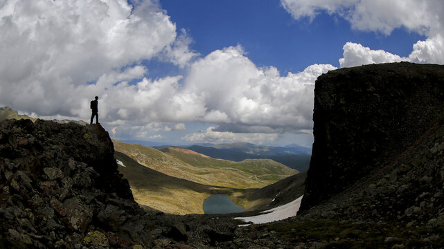 Man standing on the edge of a cliff beside a chasm - obstacles concept