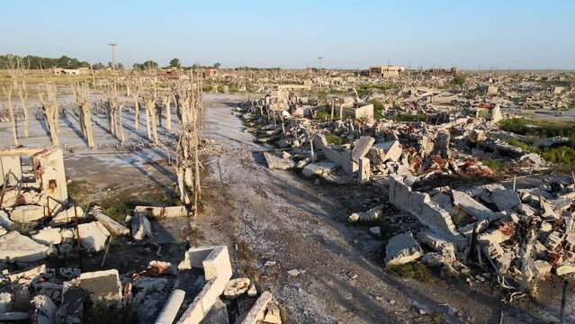 Desolate silence landscape, ruins of abandoned epecuen village, aerial drone tracking shot capturing the buildings rubbles and dead forest, the damage and destruction by the storm years ago.