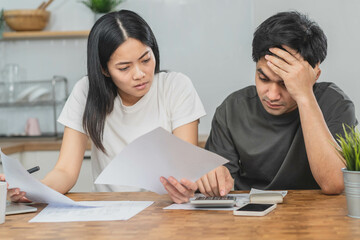 Fototapeta premium Stressed asian young couple family, wife and husband confused by calculate expense from invoice or bill, have no money to pay. Mortgage, loan causing debt, bankruptcy. Debt problems, Financial people.
