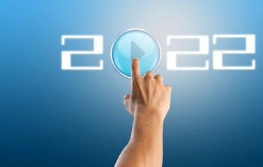 hand presses the start button for 2022. Happy New Year resolution, change, goal, vision,