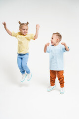Vertical photo with children. Funny kids jump and have fun. Children in sportswear. Friendship since childhood between a boy and a girl.