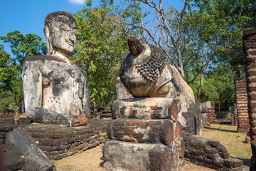 Fototapeta premium Ancient Buddha statues on the ruins of the Buddhist temple of Wat Phra Kaew. Kamphaeng Phet, Thailand