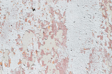 Peeling, plastered concrete wall, with remnants of paint