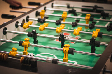 A closeup shot of table football with yellow and black players