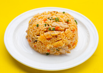 Fried rice in white plate on yellow background.