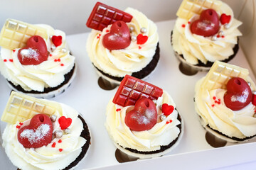 chocolate cupcakes with cream cheese frosting and festive decor. Valentine's day or birthday dessert. Beautiful festive food for a wedding or children's party.