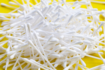 Cotton buds on yellow background.