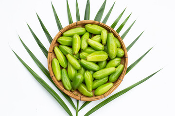 Bilimbi fruit in bamboo basket on white background.