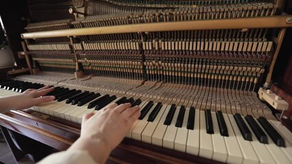Woman play on open vintage wooden piano