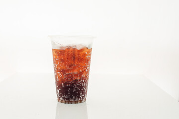 Soft drink in a plastic glass on a white background.