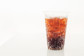Soft drink in a plastic glass on a white background.