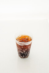 Soft drink in a plastic glass on a white background.