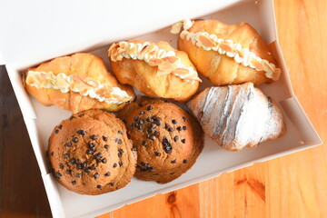 Bread in paper box on the wooden floor