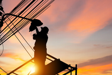 Silhouette of Electrician checking lighting to the LED street lamp post, Technician with clipping...