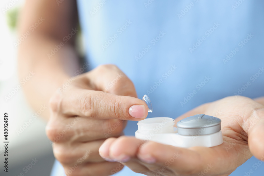 Poster soft contact lens with container in female hands closeup