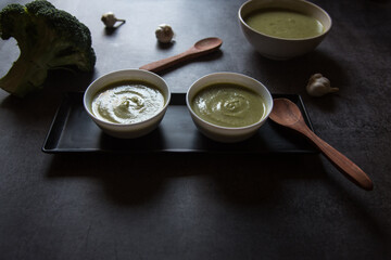 Healthy food ingredient fresh broccoli soup served on a dark background. Close up.