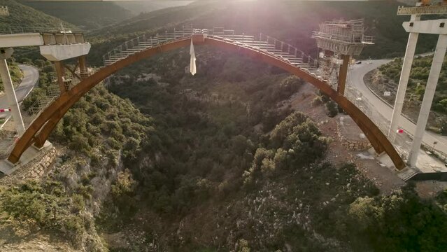 Descending drone motion video under a new bridge&acute;s structure and beam launcher over  Barranco de la Bota in Morella on a sunny afternoon