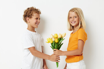 Fototapeta na wymiar Cute preschool kids with a bouquet of flowers gift birthday holiday childhood light background