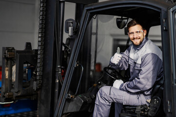 Obraz na płótnie Canvas Portrait of happy forklift driver in factory giving thumbs up for on time delivery.