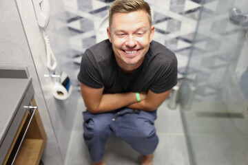 Fototapeta na wymiar Happy young man on the toilet closeup