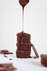 a stack of chocolate brownies on top with chocolate sauce.