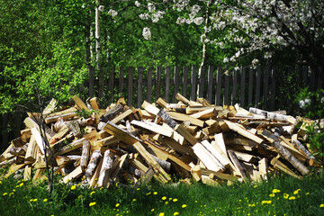 Firewood in a pallet. Chopped firewood lies on the ground. Wooden background..
