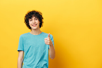 smiling guy showing thumb up yellow background