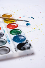 Set bright watercolor paint and a brush for watercolor painting with blots white background.