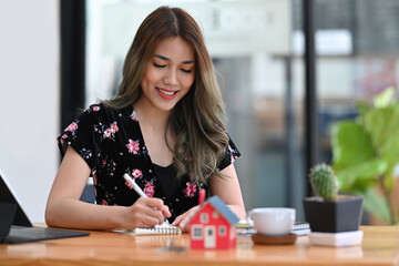 Fototapeta premium Attractive female financial advisor or real estate agent working in modern office.