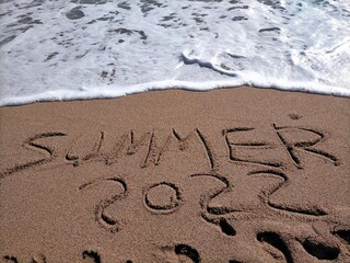 summer 2022 written in the sea sand at the foot of the wave.