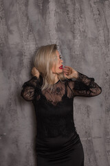 Obraz premium Attractive young woman wearing black dress on grey background