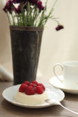 panna cotta with raspberries and a cup of coffee