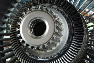 Technicians repair an aircraft gas turbine engine in the hangar. Close up of mechanics inspect an jet machine and system in aerospace industry.