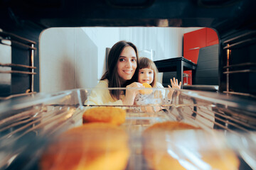 Mother and Daughter Eating Freshly Baked Patties from the Oven