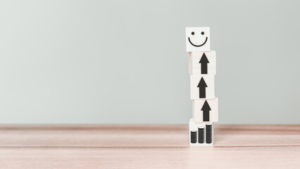 Money icon linked by icon arrow leads to happy icon on wooden cube. Business growth under the concept “happy money” from delivering good things to customers.