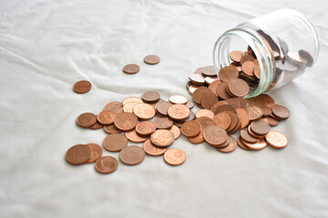 Euro cent coins spilling out from a glass jar