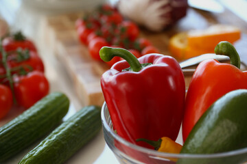 Bowl with fresh vegetables inside, ripe red pepper, cucumber, tomatoes for salad