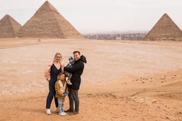 happy tourist family in Giza. holiday travel tpur near Pyramid of Khafre, Egypt. Windy...