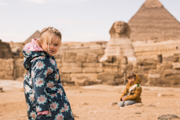 happy little girl and  boy plaing on background of Great Sphinx and Chephren's pyramid in Giza,...